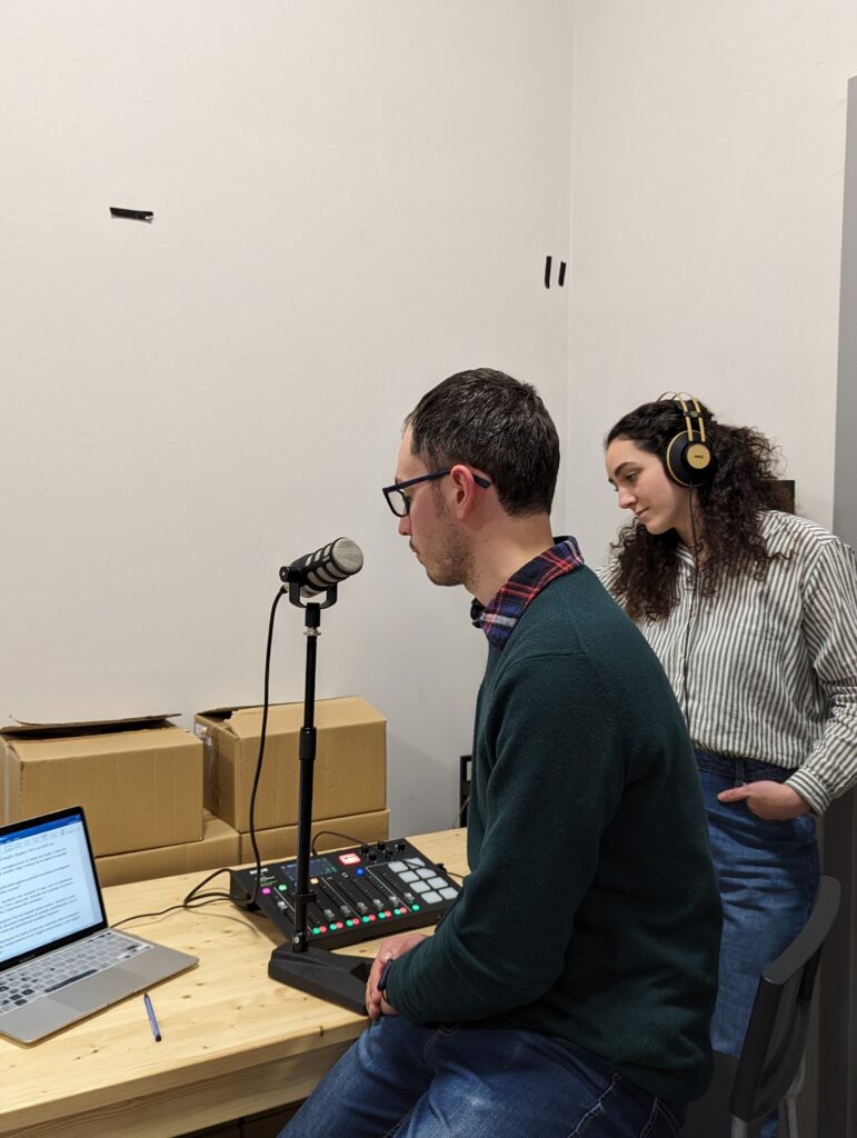Un ragazzo davanti al microfo in fase di registrazione audio.