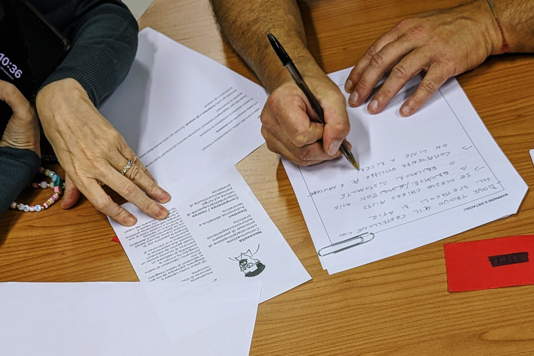 Due mani scrivono appunti durante l'attivita di role-playing in formazione.