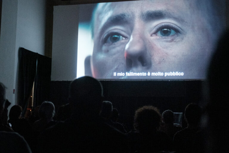 una platea guarda un film sullo schermo del cinema